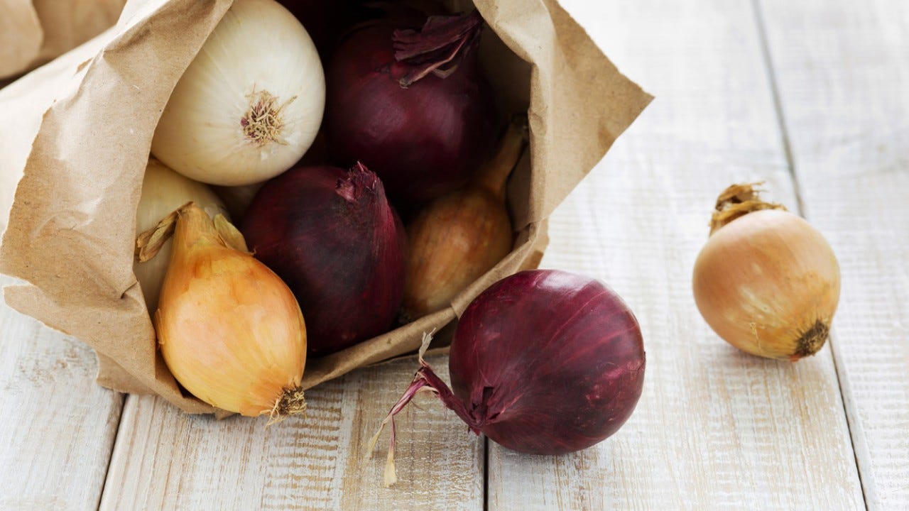 Red, white and yellow onions in a paper bag