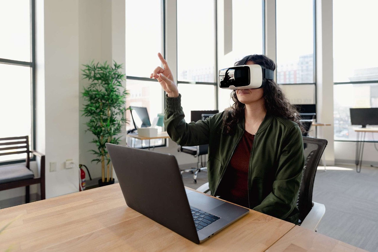 Woman in office wearing VR glasses at meeting